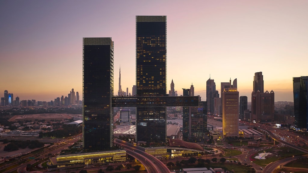 Drone shot of two cantilevered buildings in Dubai in the evening