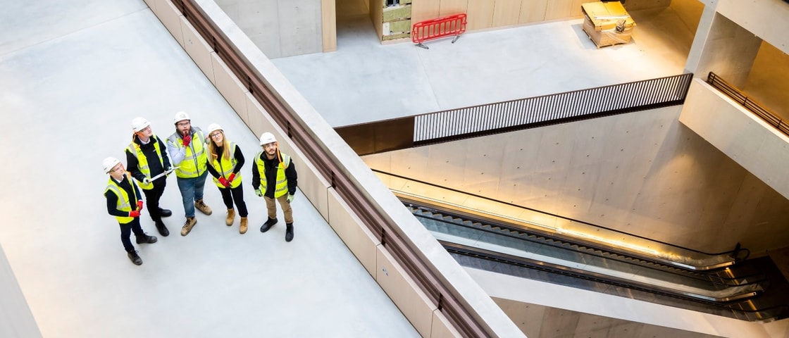 Mace colleagues standing together in the University College London lobby 
