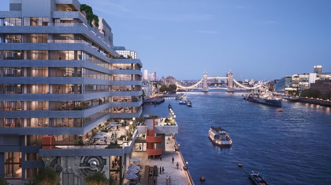 A CGI architectural rendering of a modern riverside building overlooking the River Thames at dusk. The multi-storey development features large glazed windows, stepped terraces, rooftop planting and active waterfront spaces with outdoor seating and pedestrians. Tower Bridge is illuminated in the background, while several boats travel along the river, framed by the London skyline under a blue evening sky.