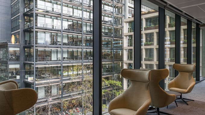 Open-plan workspace at Taylor Wessing featuring contemporary furnishings, collaborative seating areas, and natural light from large windows.