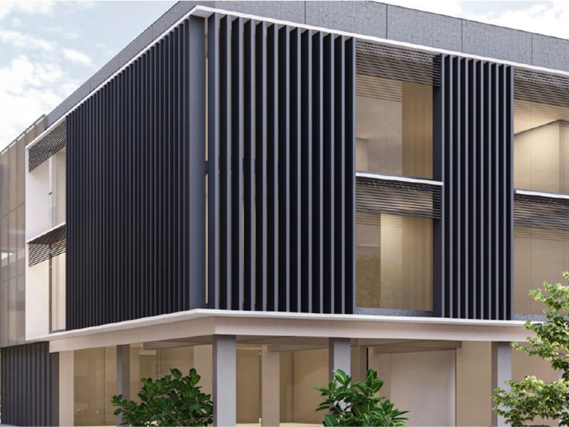 Modern architectural design featuring a sleek building with black vertical slats, large windows, and greenery in the foreground.