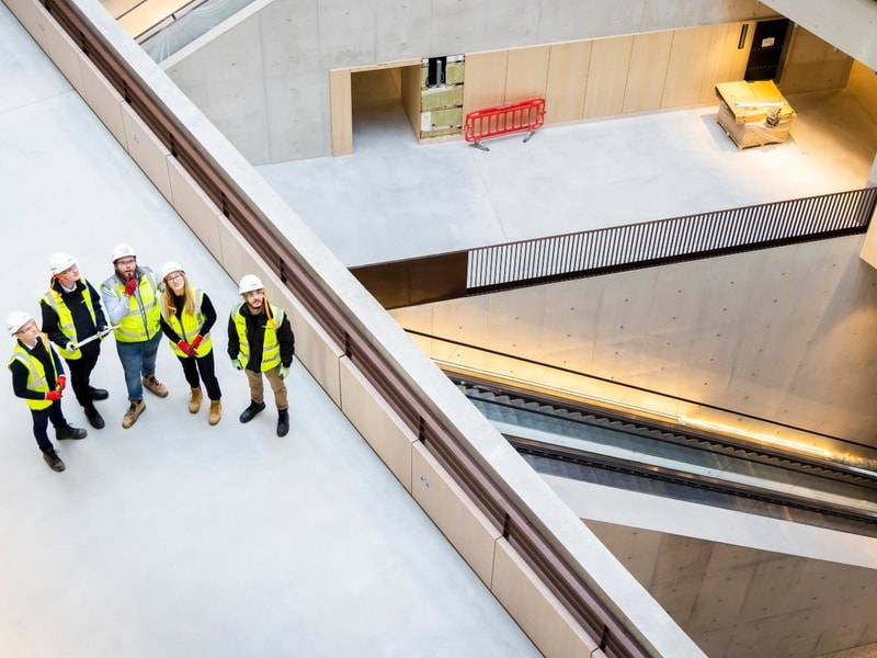 Mace colleagues standing together in the University College London lobby 